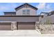 Front exterior showcasing a two-car garage with stone accents and a concrete driveway at 8145 Monte Vista Cir, Littleton, CO 80125