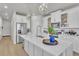 Well-lit kitchen with an island and quartz countertop, stainless steel appliances, and wood flooring at 8145 Monte Vista Cir, Littleton, CO 80125