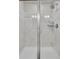 Shower room with white tile, glass door and shower head at 8145 Monte Vista Cir, Littleton, CO 80125