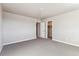 Spacious bedroom with soft carpet, neutral walls, and doorways leading to a closet and other rooms at 4284 Gozzer Ranch Dr, Elizabeth, CO 80107