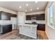 Beautiful kitchen with an island, stainless appliances, dark cabinets and a white backsplash and countertops at 4284 Gozzer Ranch Dr, Elizabeth, CO 80107