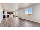 Open-concept living room featuring wood floors and an adjacent kitchen at 4284 Gozzer Ranch Dr, Elizabeth, CO 80107