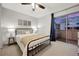 Bedroom with a black metal bed frame, ceiling fan, and sliding door to a private deck with outdoor views at 4110 Hale Pkwy Pkwy # 4J, Denver, CO 80220
