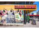 A vibrant exterior view of Culinary Dropout with colorful murals and a neon sign, set against a clear blue sky at 4110 Hale Pkwy Pkwy # 4J, Denver, CO 80220