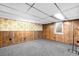 Cozy finished basement with wood paneling, patterned wallpaper, and carpet flooring at 625 Ammons St, Lakewood, CO 80214