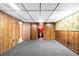 Finished basement area featuring wood paneling, patterned wallpaper and nearby bathroom at 625 Ammons St, Lakewood, CO 80214