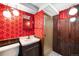 Finished basement bathroom features vintage wallpaper, wooden paneling, and walk in shower at 625 Ammons St, Lakewood, CO 80214