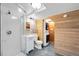 Compact bathroom features stand up shower, stacked washer/dryer, and wood accent wall at 625 Ammons St, Lakewood, CO 80214