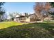 Spacious ranch-style home with a lush lawn, mature tree, and covered porch, perfect for outdoor living at 625 Ammons St, Lakewood, CO 80214