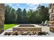 Landscaped backyard featuring a stone fire pit, lush lawn, mature trees, and outdoor seating at 2 Viking Dr, Englewood, CO 80113
