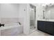 Modern bathroom with a soaking tub, glass-enclosed shower, and a sleek vanity at 2 Viking Dr, Englewood, CO 80113