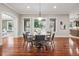 Open dining room with hardwood floors and a round table with seating for six near large windows at 2 Viking Dr, Englewood, CO 80113