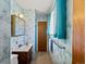 Compact bathroom featuring blue wallpaper, a vanity, and bright natural light at 3018 S Depew St, Denver, CO 80227