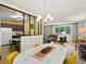 Bright dining room with an oval table, yellow chairs, and chandelier lighting at 3018 S Depew St, Denver, CO 80227