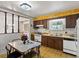 Charming kitchen with patterned wallpaper, vintage cabinets, and a bright window overlooking the yard at 3018 S Depew St, Denver, CO 80227