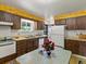 Cozy kitchen with wood cabinets, vintage wallpaper, laminate countertops, and stainless sink at 3018 S Depew St, Denver, CO 80227