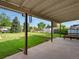 Outdoor patio offering a view of a well-maintained backyard with mature trees and storage buildings at 3018 S Depew St, Denver, CO 80227