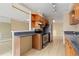 Galley kitchen with dark countertops, stainless steel appliances, and blond wood cabinets at 2880 S Locust St # 708S, Denver, CO 80222