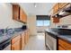 Kitchen with wood cabinets, granite countertops, stainless steel appliances, and sliding doors to a balcony at 2880 S Locust St # 708S, Denver, CO 80222
