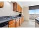 Kitchen with wood cabinets, granite countertops, stainless steel appliances, and sliding doors to a balcony at 2880 S Locust St # 708S, Denver, CO 80222