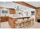 Bright kitchen features an island with bar seating, stainless steel appliances, and wood beam accents at 1189 Lodgepole Dr, Evergreen, CO 80439