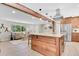 Bright living room and kitchen with stone accents, stainless appliances, hardwood floors, and natural light at 1189 Lodgepole Dr, Evergreen, CO 80439