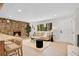 Open-concept living room with a stone fireplace, hardwood floors, and comfortable seating at 1189 Lodgepole Dr, Evergreen, CO 80439
