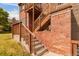 Brick and wood townhome exterior featuring a wooden staircase and concrete steps at 2296 S Pitkin Way # A, Aurora, CO 80013