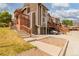 Inviting townhome featuring wood and brick facade with wooden stairs and partial basement at 2296 S Pitkin Way # A, Aurora, CO 80013