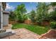 Private backyard oasis, fully fenced with a stone patio, lush lawn, and mature trees for shade at 602 Mathews Way, Erie, CO 80516