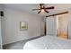 Bright bedroom with a ceiling fan, neutral tones, and a sliding barn door leading to bathroom at 602 Mathews Way, Erie, CO 80516