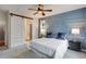 Comfortable bedroom with modern accent wall, ceiling fan, and sliding barn door to bathroom at 602 Mathews Way, Erie, CO 80516