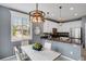 Inviting dining area featuring a stylish chandelier, ample natural light, and convenient access to the kitchen at 602 Mathews Way, Erie, CO 80516