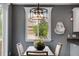 Bright dining area features modern light fixture, large window, and neutral tones at 602 Mathews Way, Erie, CO 80516
