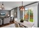 Bright dining area with sliding door, modern lighting, open to the living room at 602 Mathews Way, Erie, CO 80516