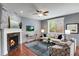 Cozy living room featuring a fireplace, modern ceiling fan, and comfortable seating area with natural light at 602 Mathews Way, Erie, CO 80516