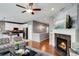 Open-concept living room featuring a fireplace, ceiling fan, and seamless flow into the modern kitchen at 602 Mathews Way, Erie, CO 80516