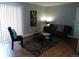 Living room with wood floors, a dark couch, and window blinds at 10792 E Exposition Ave Ave # 254, Aurora, CO 80012