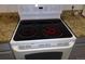A glass top stove in the kitchen with granite countertops at 10792 E Exposition Ave Ave # 254, Aurora, CO 80012
