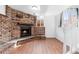 Basement living area featuring a striking brick fireplace and wood flooring at 5721 W 92Nd Ave # 52, Westminster, CO 80031