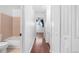 Hallway leading to a bathroom, with wood-look floors and white walls creating a clean and modern aesthetic at 5721 W 92Nd Ave # 52, Westminster, CO 80031