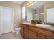 Clean bathroom with double sinks, wooden cabinets, and large mirror and overhead lighting at 7809 Bandit Dr, Castle Rock, CO 80108