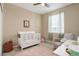 Charming bedroom featuring a crib, window with curtains, and a comfortable armchair at 7809 Bandit Dr, Castle Rock, CO 80108