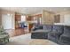Open-concept living room with a gray sectional sofa adjacent to kitchen with wooden cabinets at 7809 Bandit Dr, Castle Rock, CO 80108