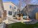 A spacious backyard with a stone retaining wall, patio furniture, and low-maintenance artificial turf at 2755 Geneva St, Denver, CO 80238