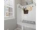 Mudroom with bench seating, hat hooks, overhead storage, and natural light from a window at 2755 Geneva St, Denver, CO 80238