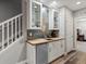 Basement wet bar with butcher block countertop, stainless mini fridge, and glass-front cabinets at 2755 Geneva St, Denver, CO 80238