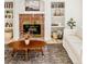 Bright living room featuring a brick fireplace, built-in shelves, and hardwood floors at 17990 E Dickenson Pl, Aurora, CO 80013