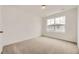 Bright bedroom with large window and neutral carpeting offers a serene living space at 7293 Waterleaf Trl, Littleton, CO 80125