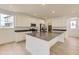 Modern kitchen with stainless steel appliances, large island, and sleek gray countertops at 7293 Waterleaf Trl, Littleton, CO 80125